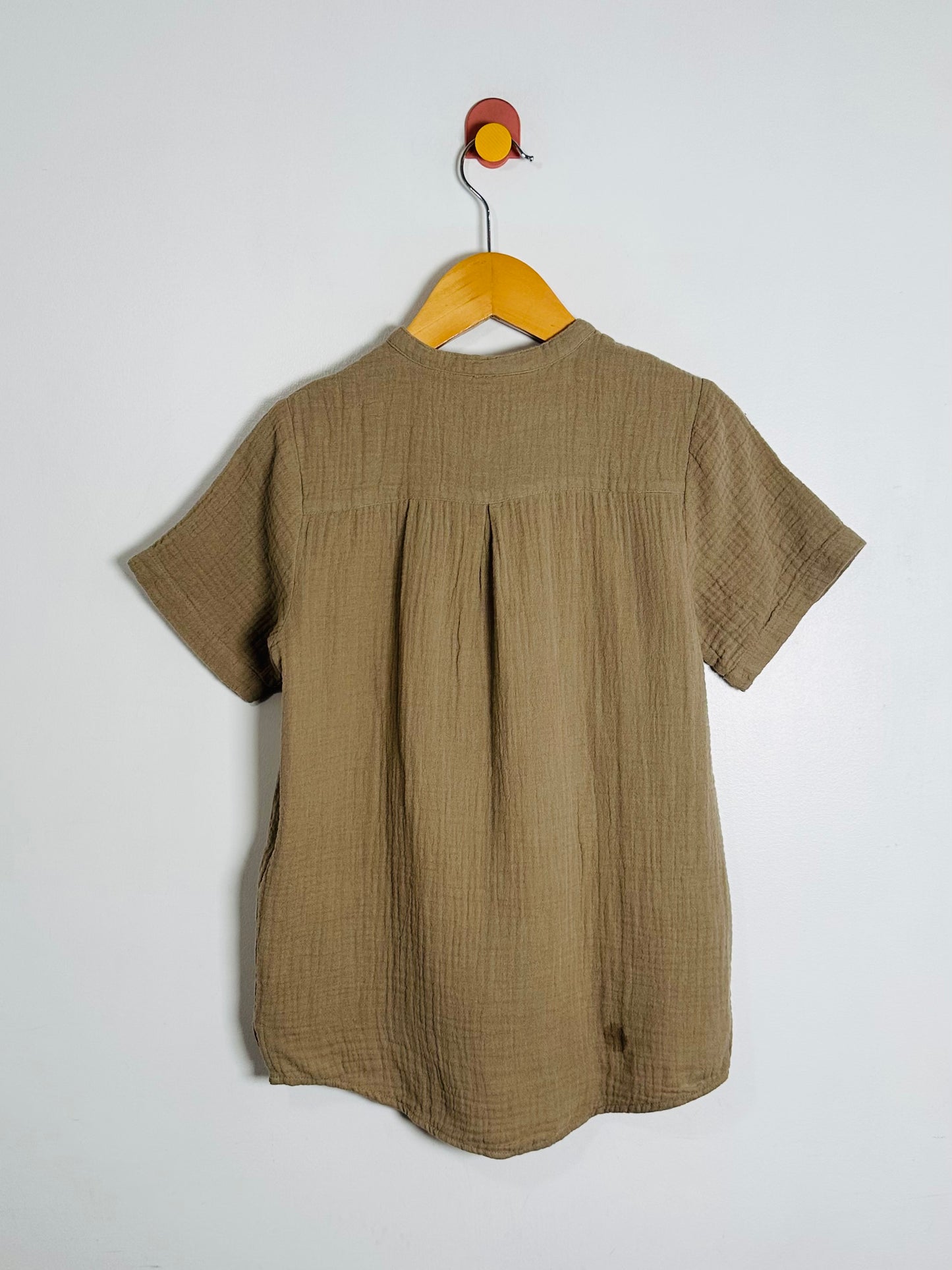 Green shirt on a hanger against a white background