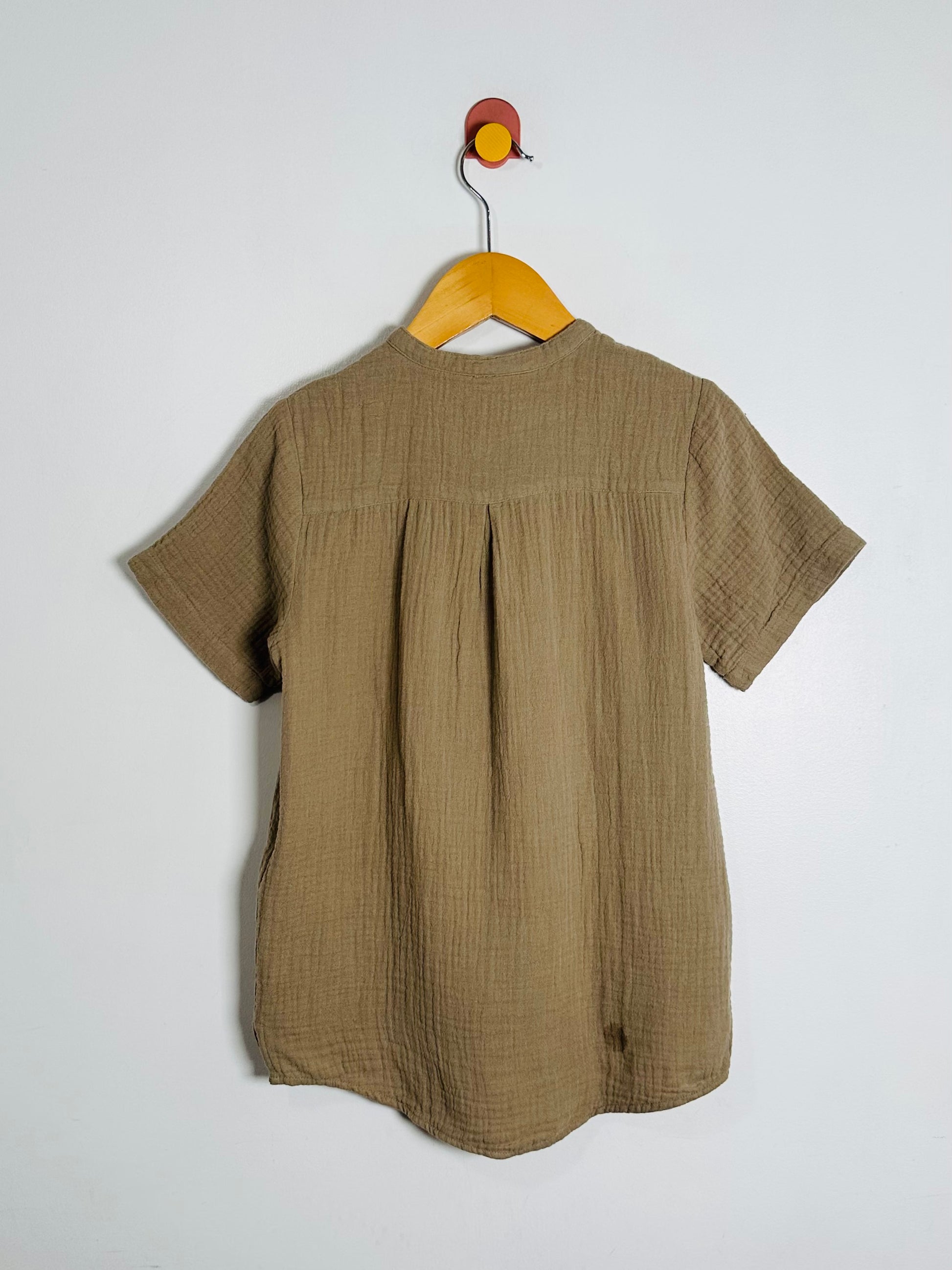 Green shirt on a hanger against a white background