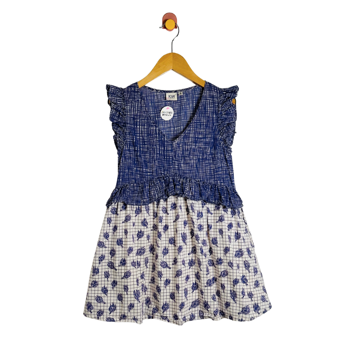 Blue and white patterned dress on a hanger against a white background