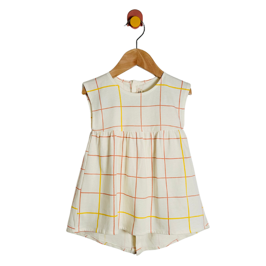 White dress with red and orange grid pattern on a wooden hanger against a white background
