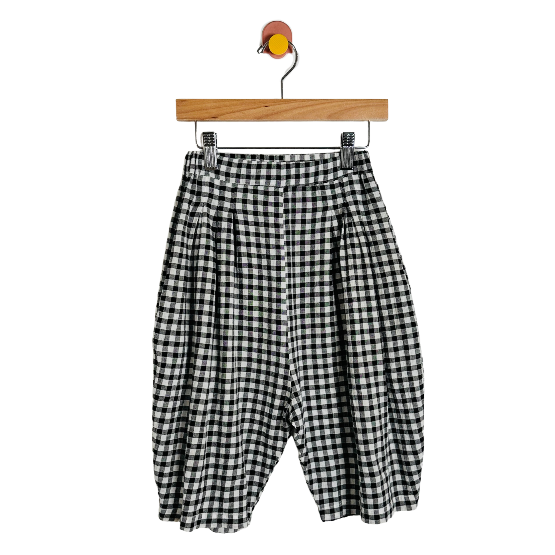 Black and white checkered pants on a wooden hanger against a white background