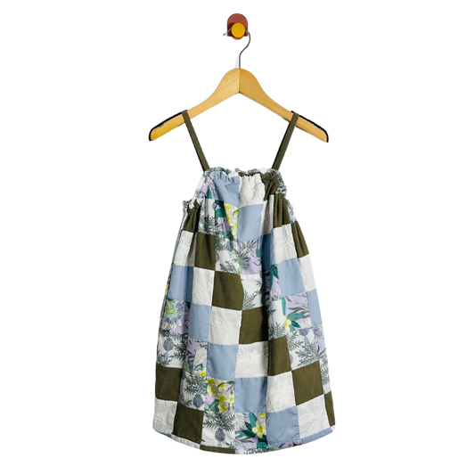 Patchwork dress on a hanger against a white background