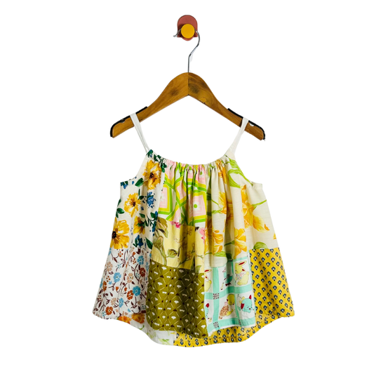 Colorful floral dress on a hanger against a white background