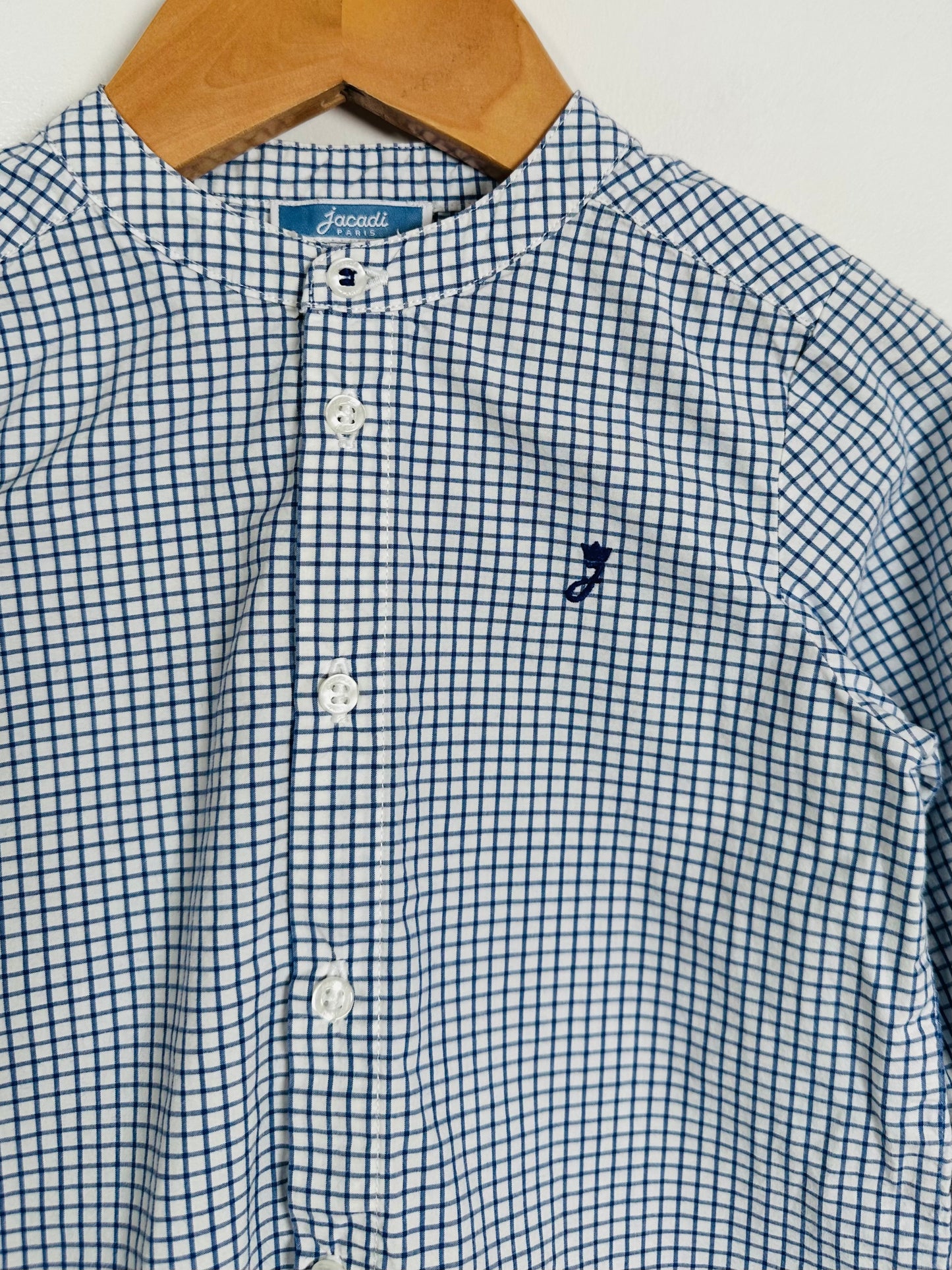 Blue and white checkered shirt with a small logo on a hanger