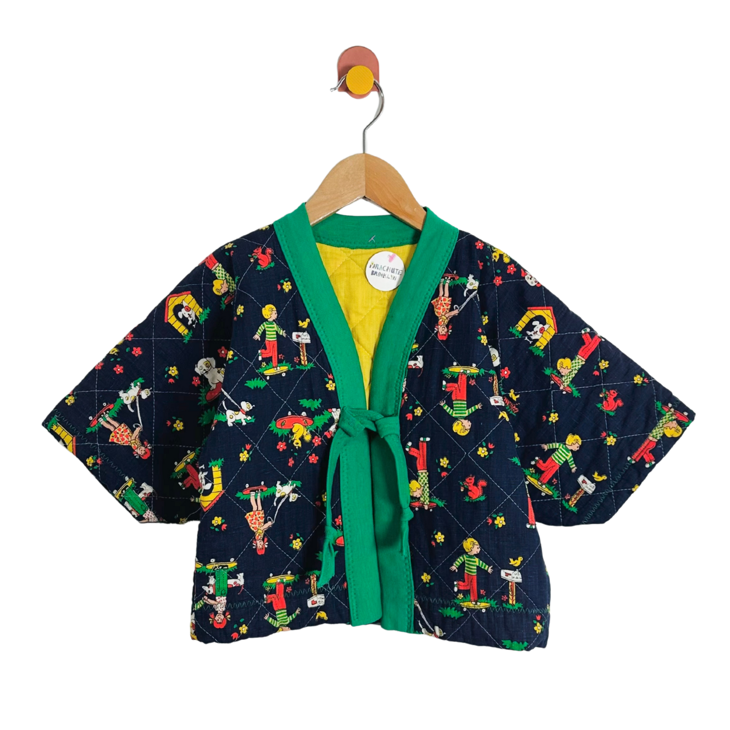 Children's kimono-style jacket with colorful pattern on a hanger against a white background