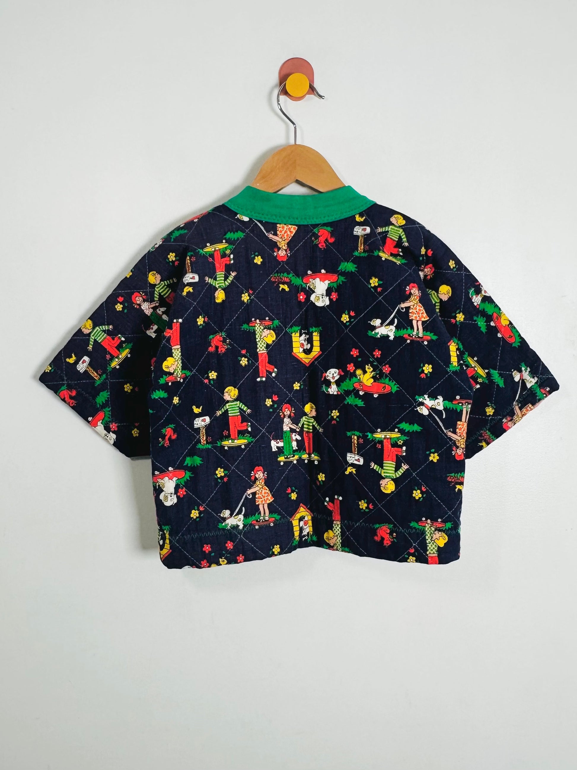 Children's jacket with colorful pattern on a hanger against a white background