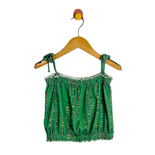 Green patterned top on a wooden hanger against a white background