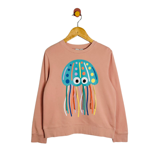 Pink sweatshirt with a colorful jellyfish design on a hanger against a white background