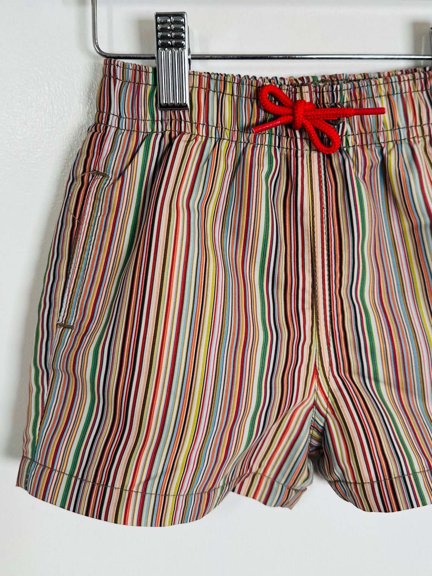 Multicolored striped shorts with a red drawstring on a white background