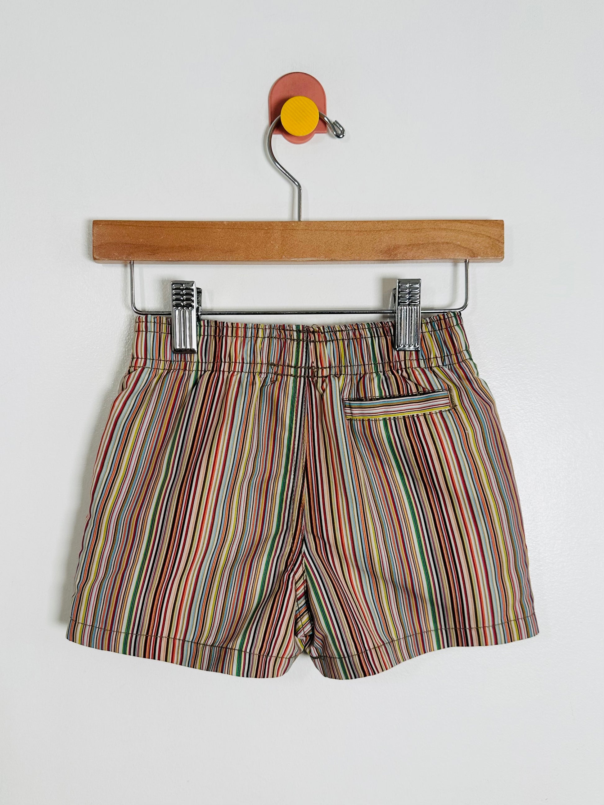 Striped shorts on a hanger against a white background