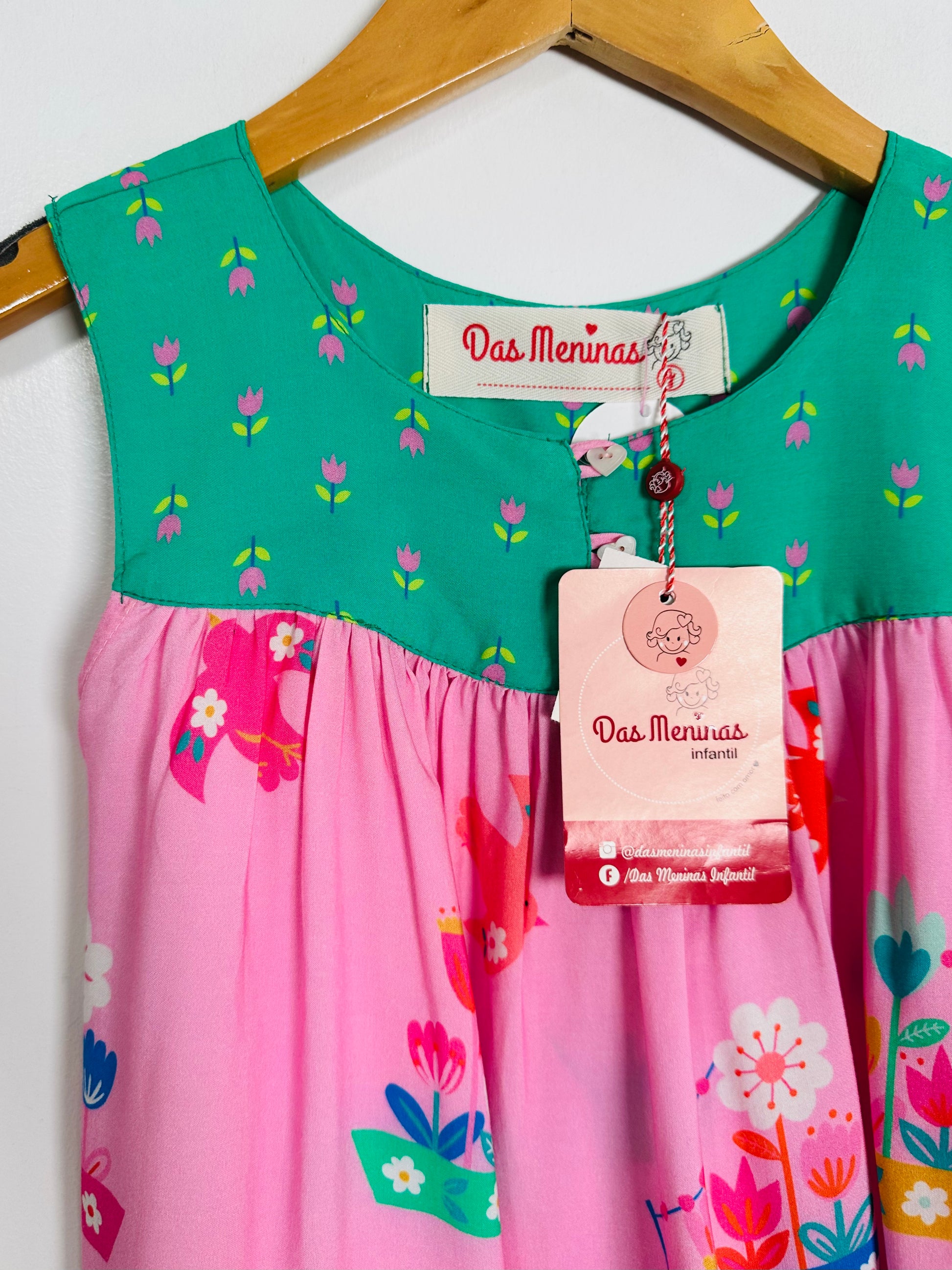 Children's top with floral patterns on a hanger, featuring 'Das Meninas' brand tags.