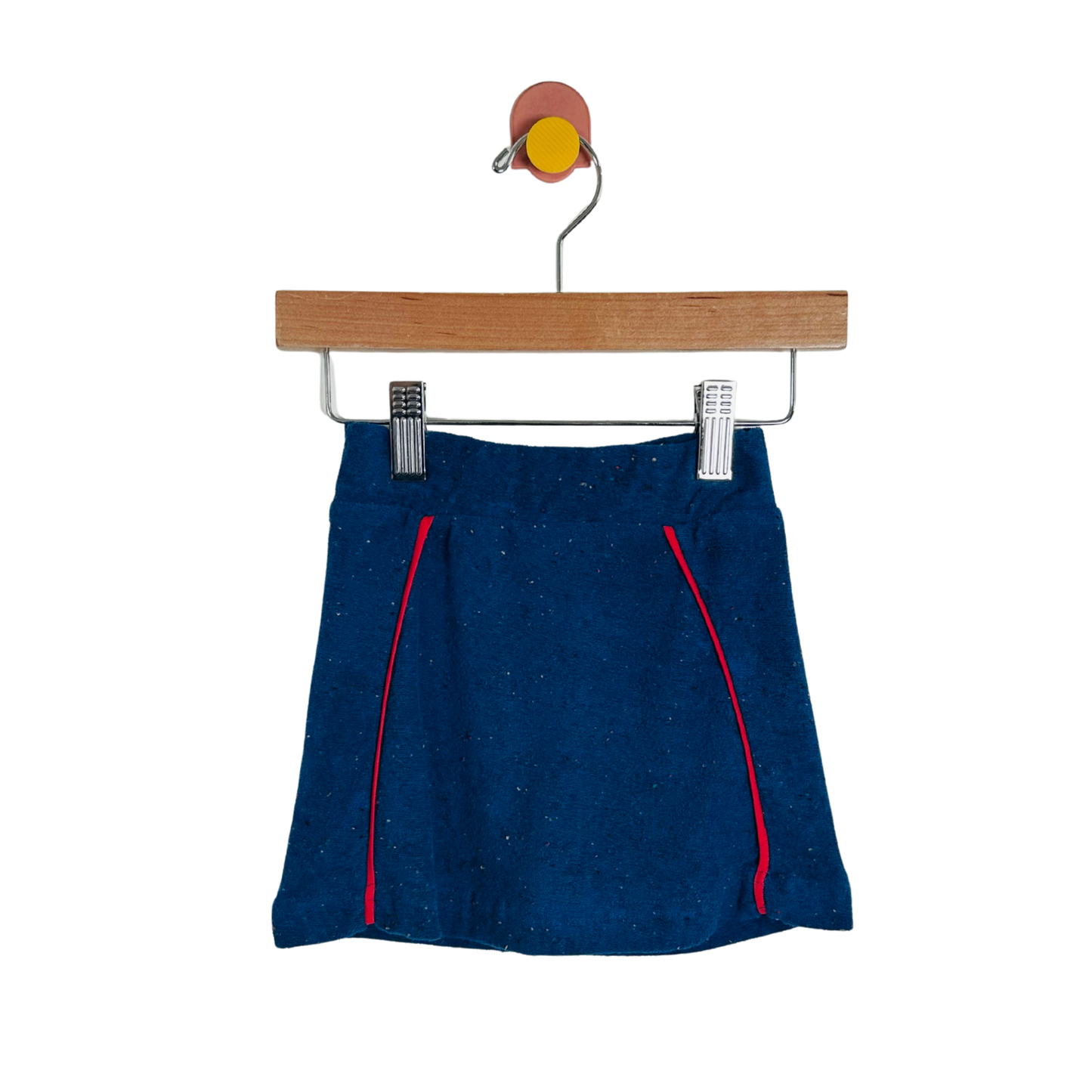 Blue skirt with red accents on a wooden hanger against a white background