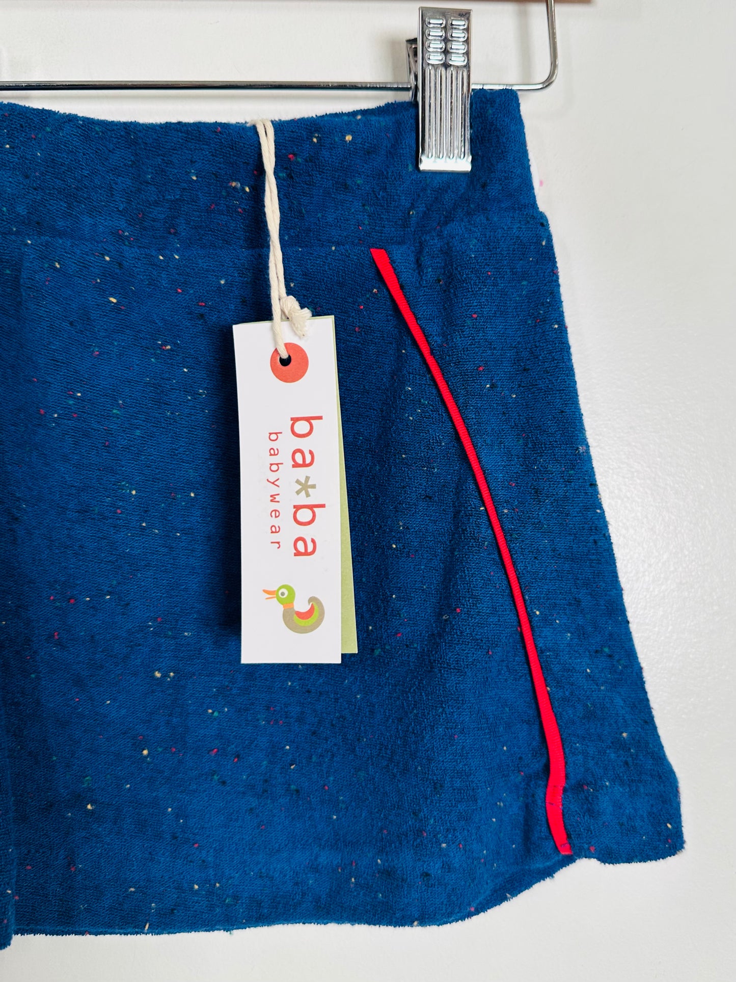 Blue skirt with a red stripe and a 'baba jeans' tag on a white background