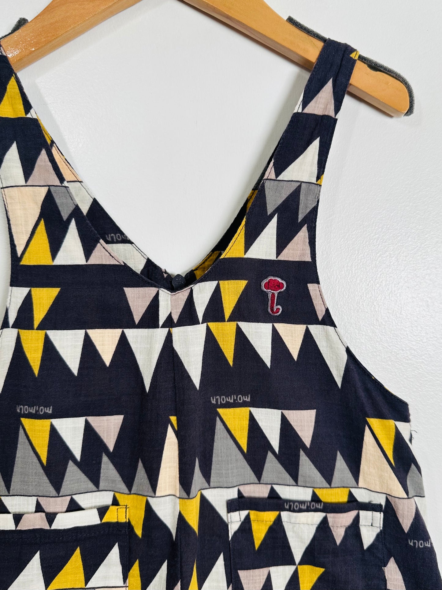 Geometric patterned top on a hanger against a white background