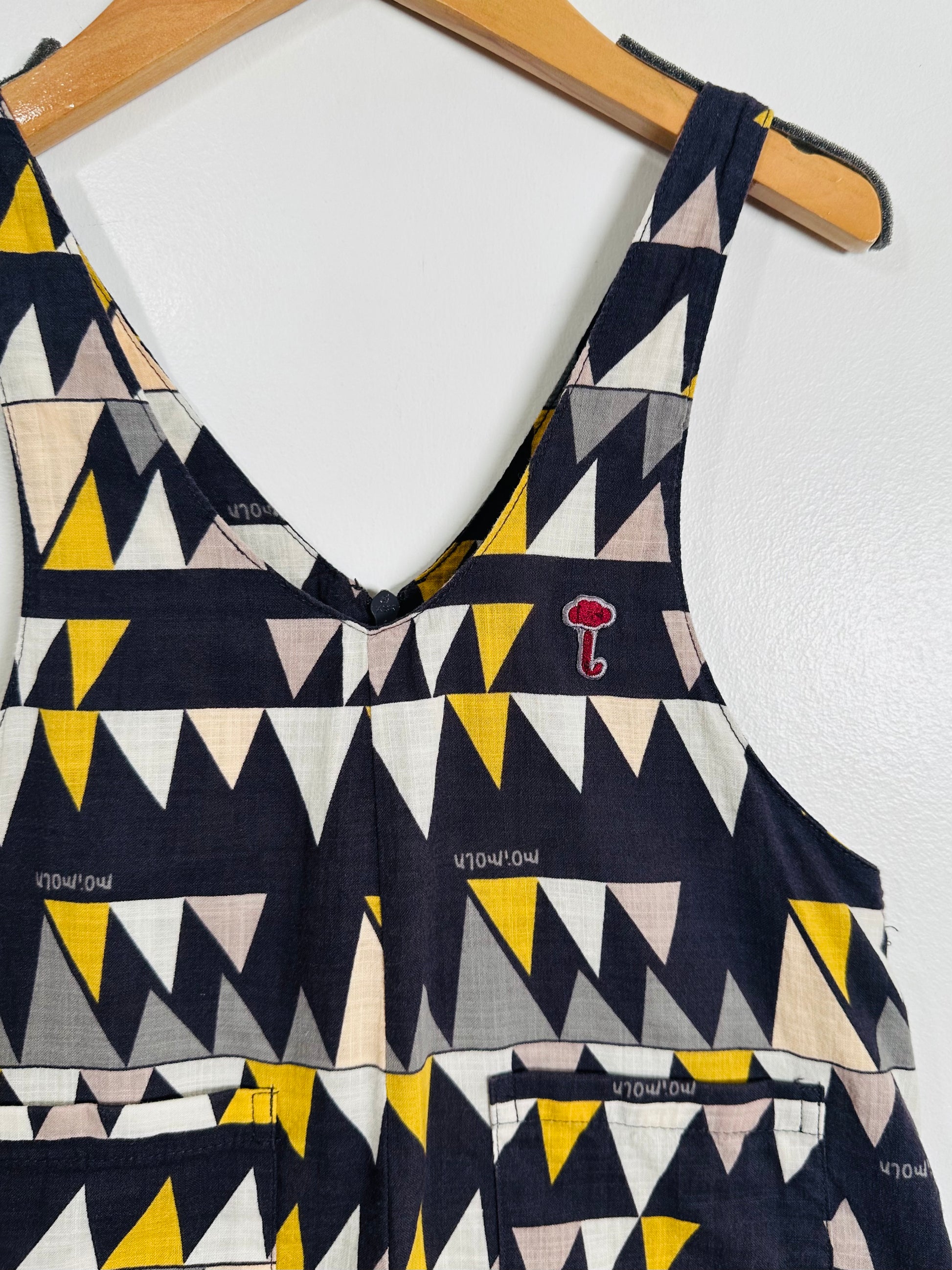 Geometric patterned top on a hanger against a white background