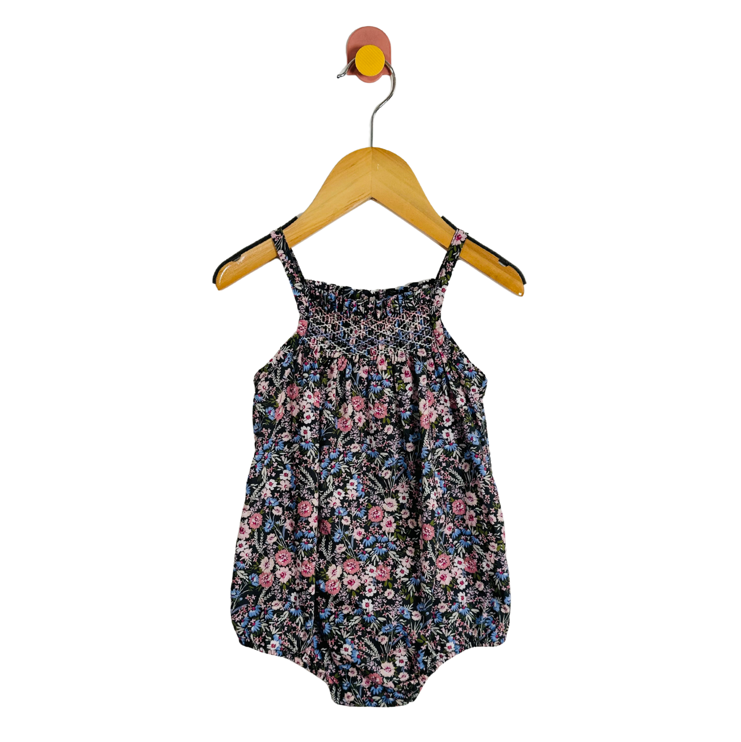 Floral baby romper on a hanger against a white background