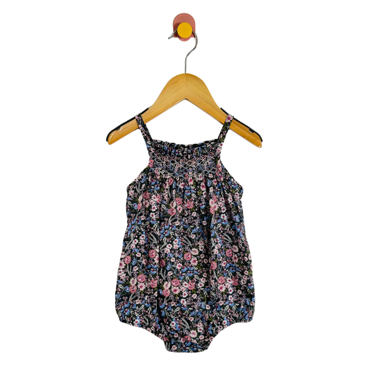 Floral baby romper on a hanger against a white background