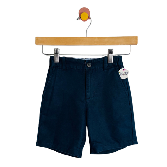 Navy blue shorts on a hanger with a white background