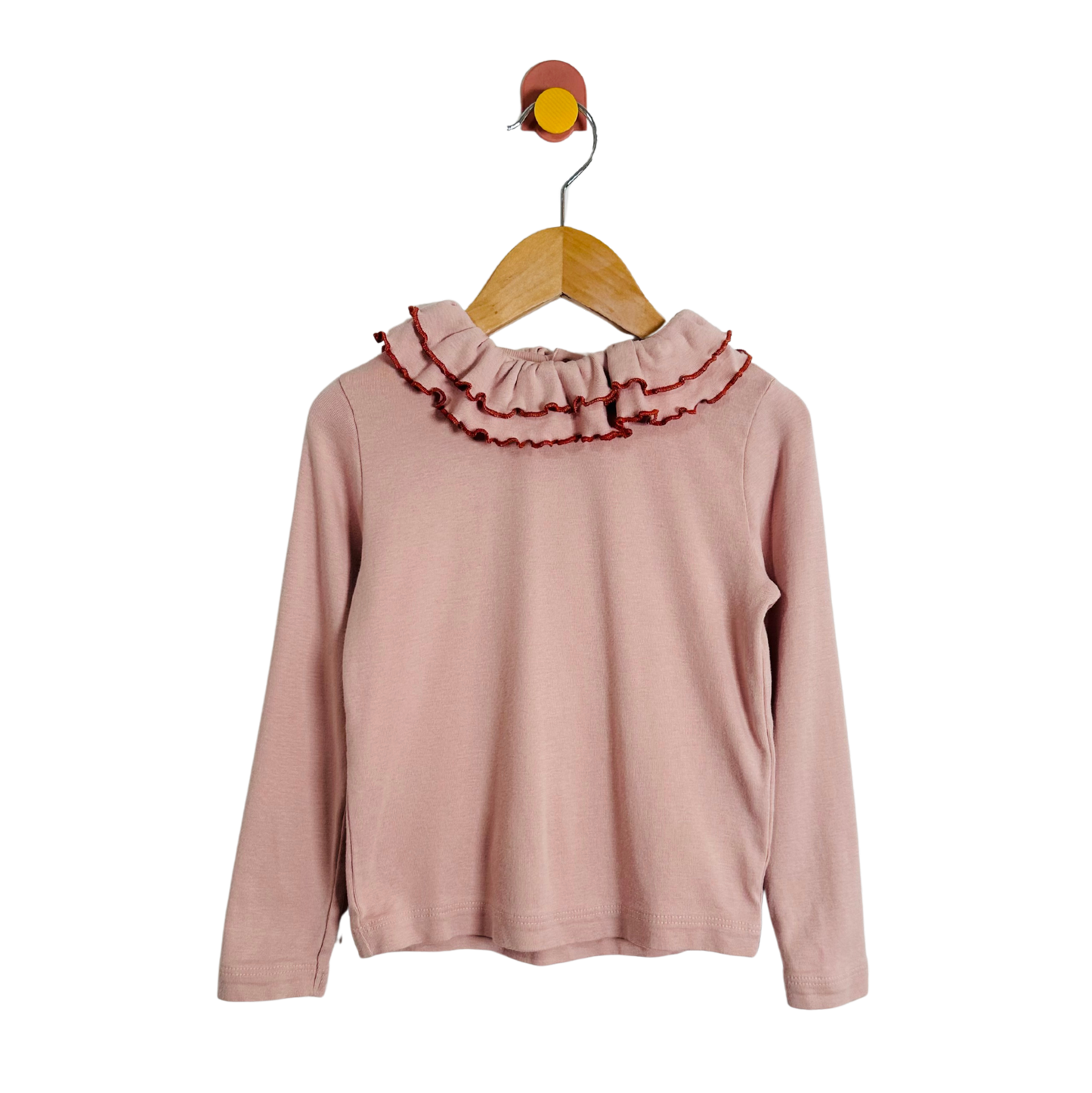 Pink long-sleeve top with ruffled collar on a hanger against a white background