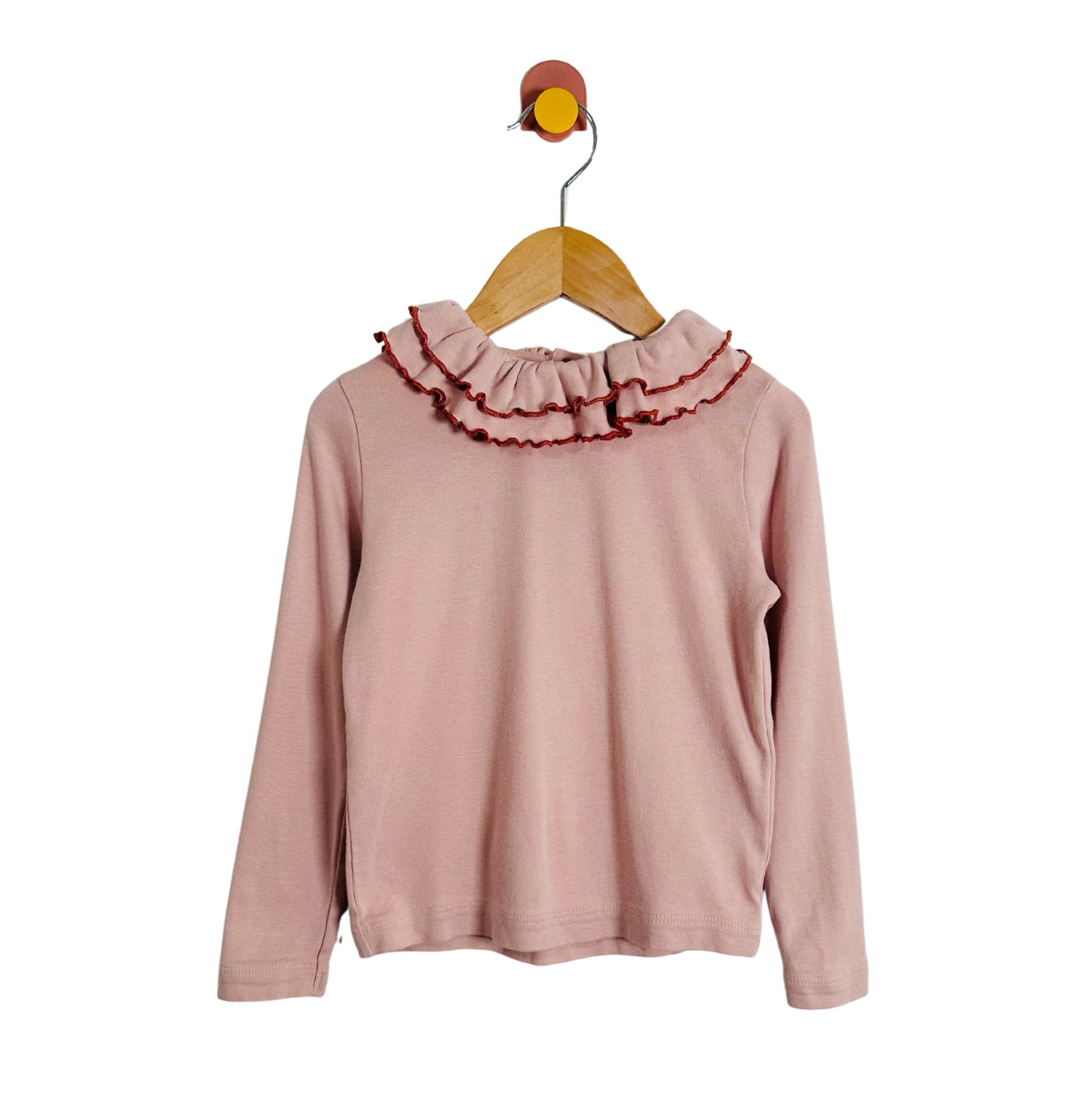 Pink long-sleeve top with ruffled collar on a hanger against a white background