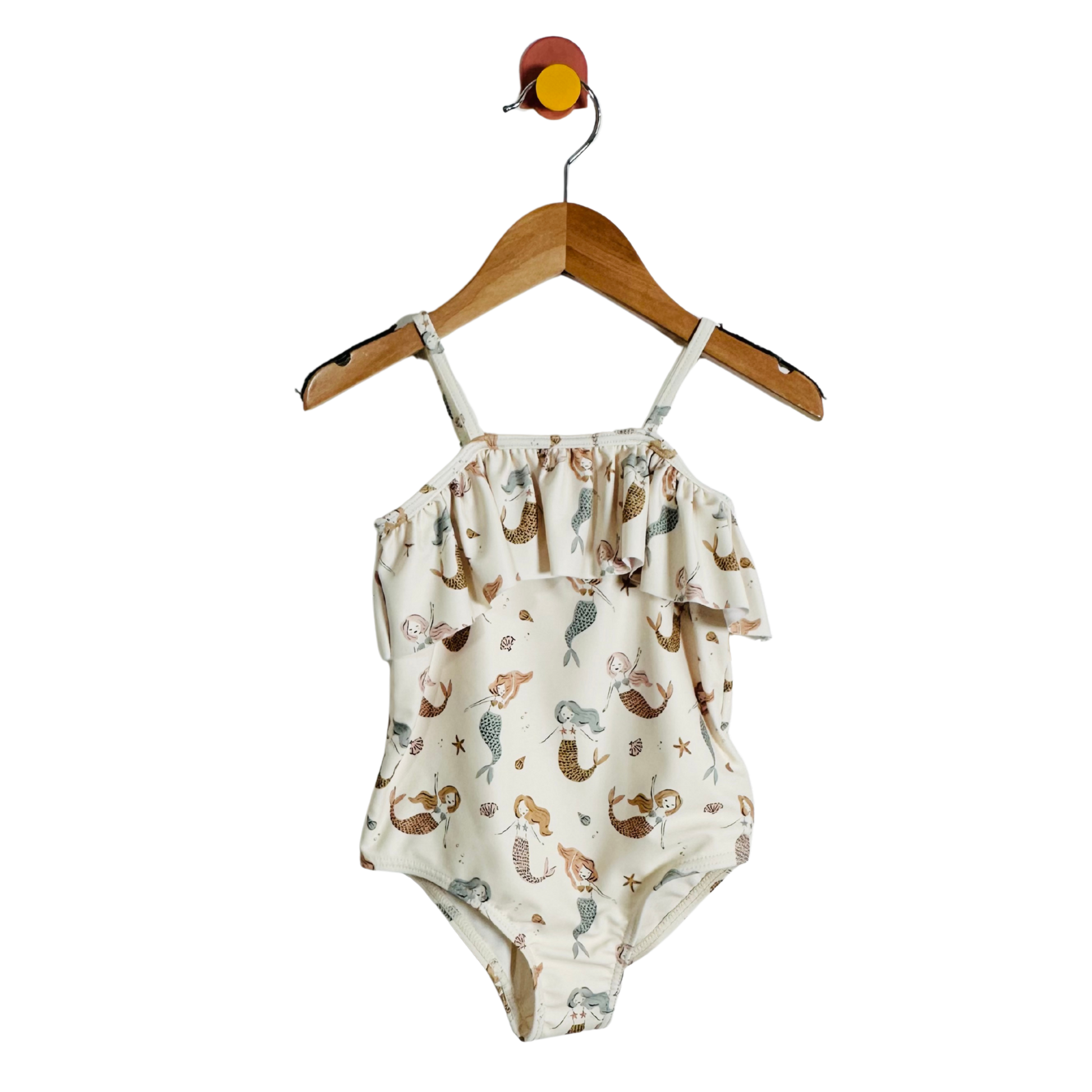 Swimsuit with mermaid pattern on a hanger against a white background