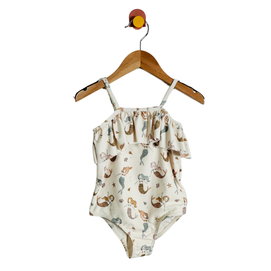 Swimsuit with mermaid pattern on a hanger against a white background