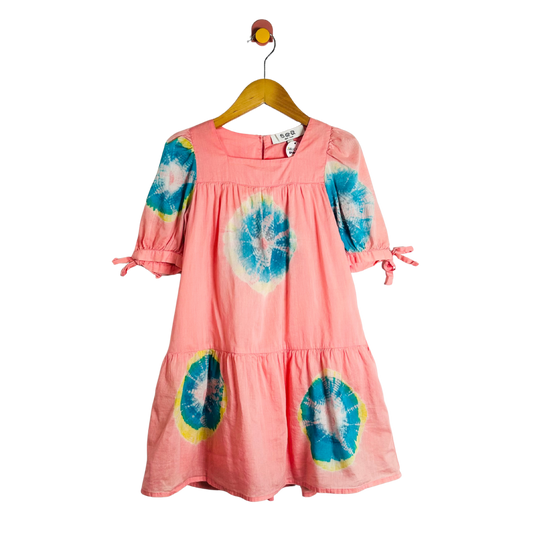 Pink dress with tie-dye patterns on a hanger against a white background
