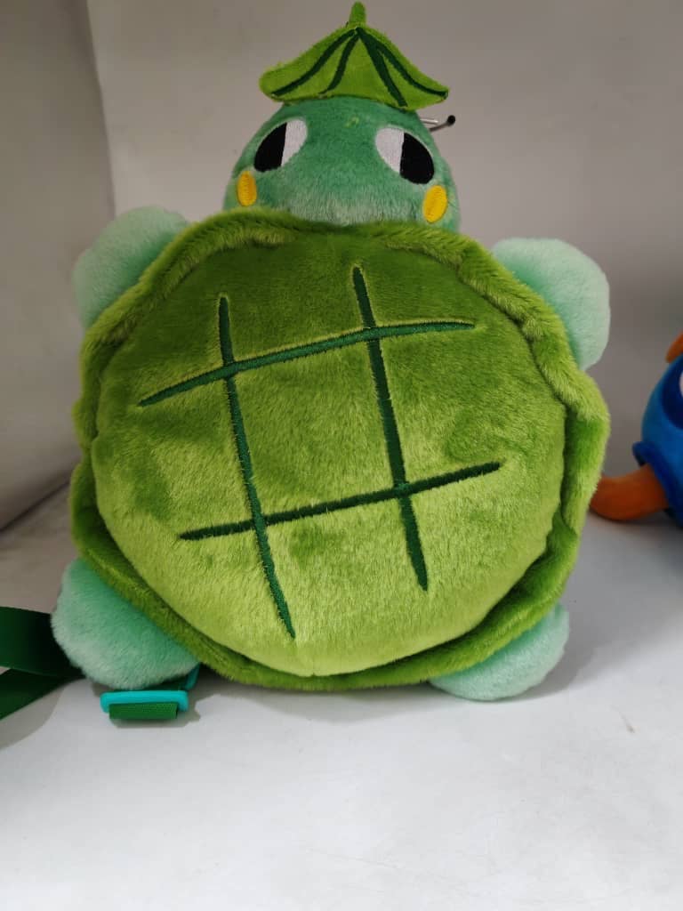 Green plush turtle toy with a white background