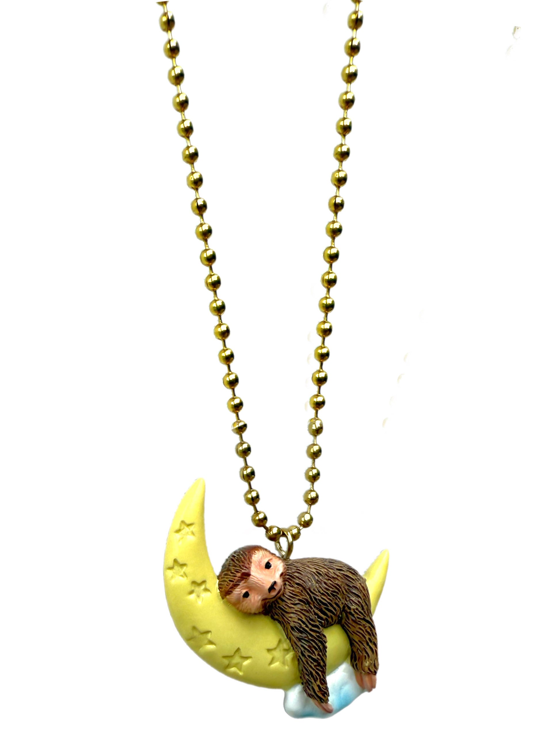 Necklace with a sloth on a moon pendant on a white background