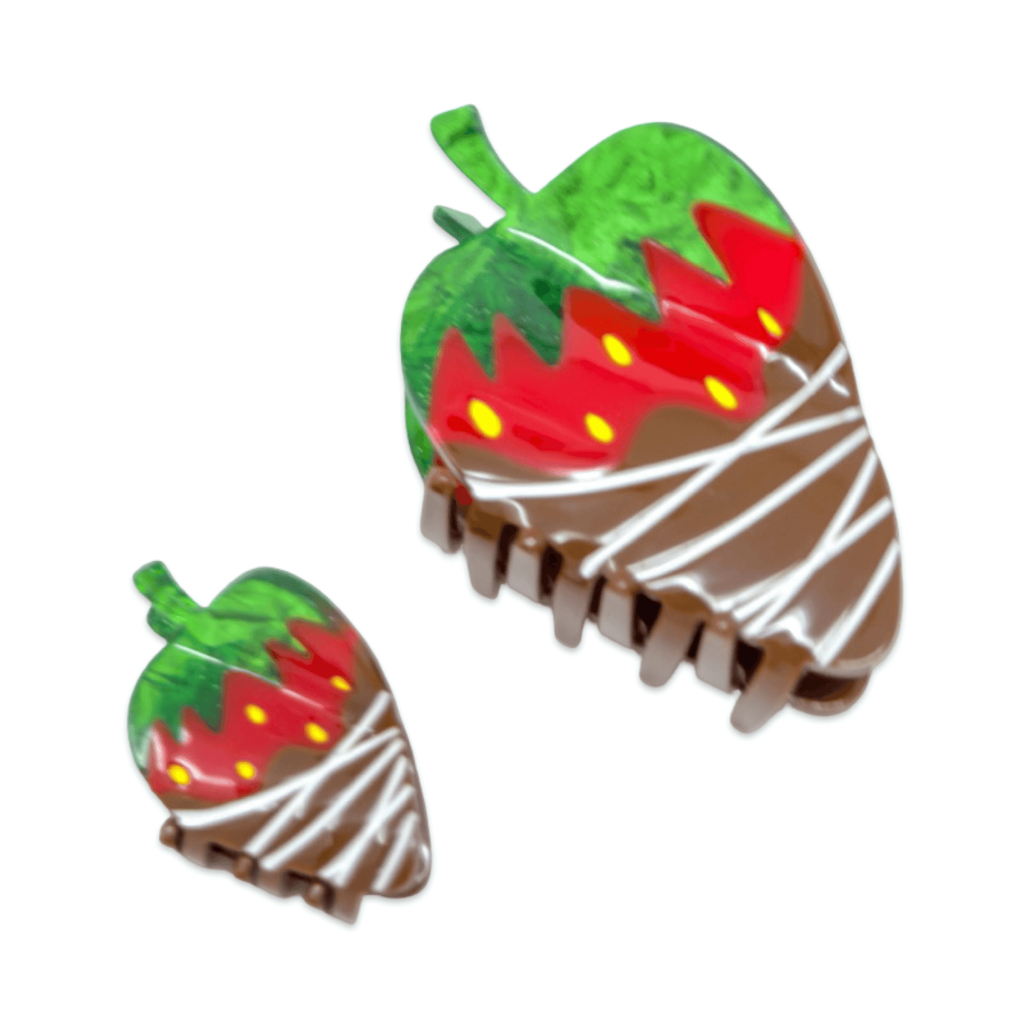 Two strawberry-shaped hair clips with chocolate drizzle design on a white background