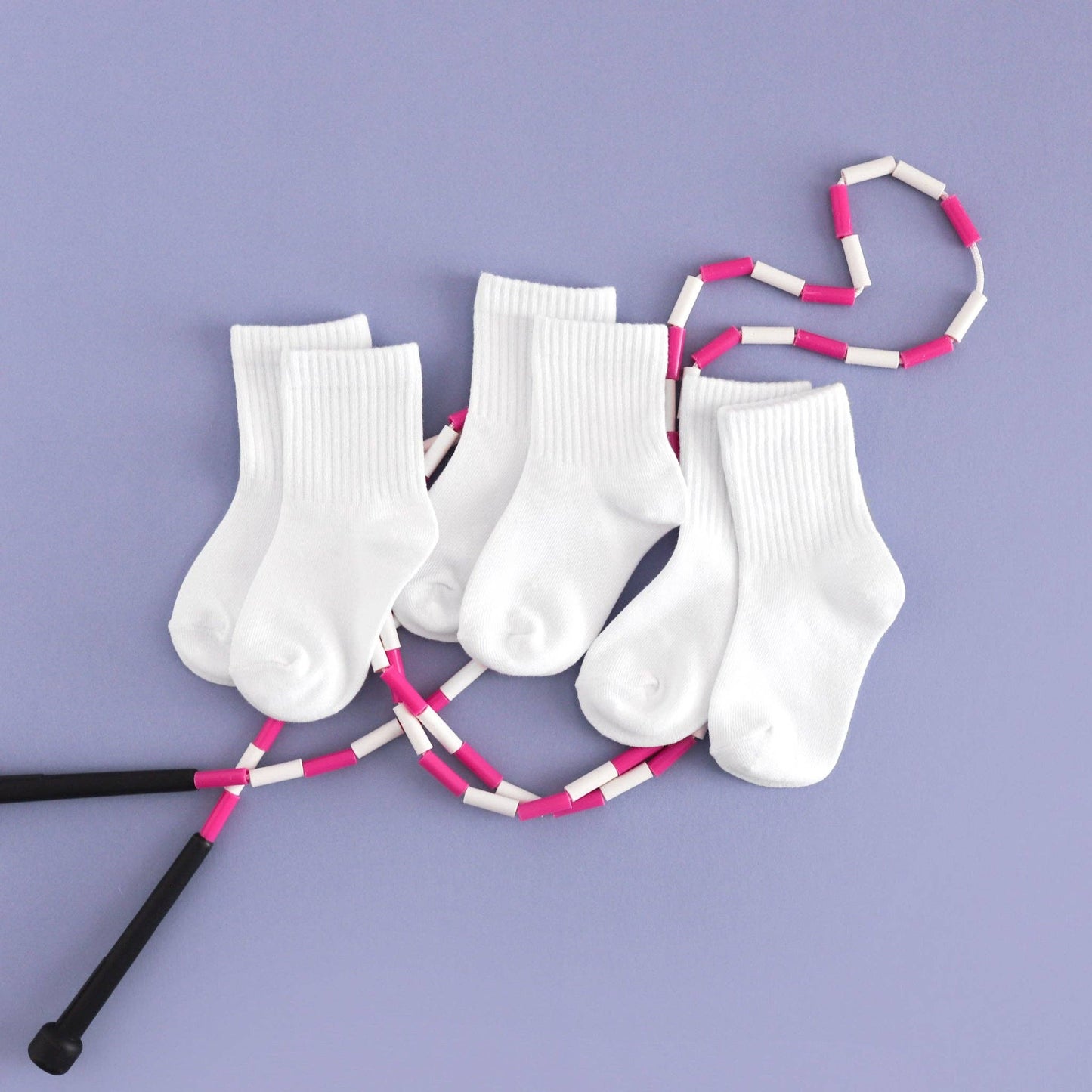 White socks with pink and black sticks on a purple background
