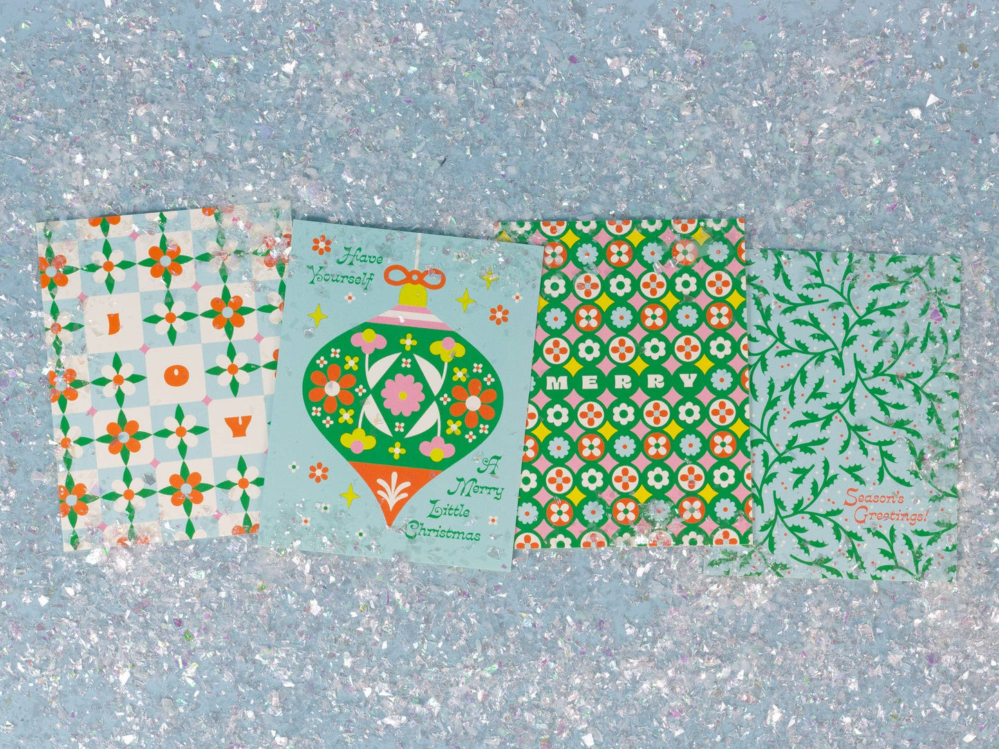 Four different patterned paper sheets on a textured blue background