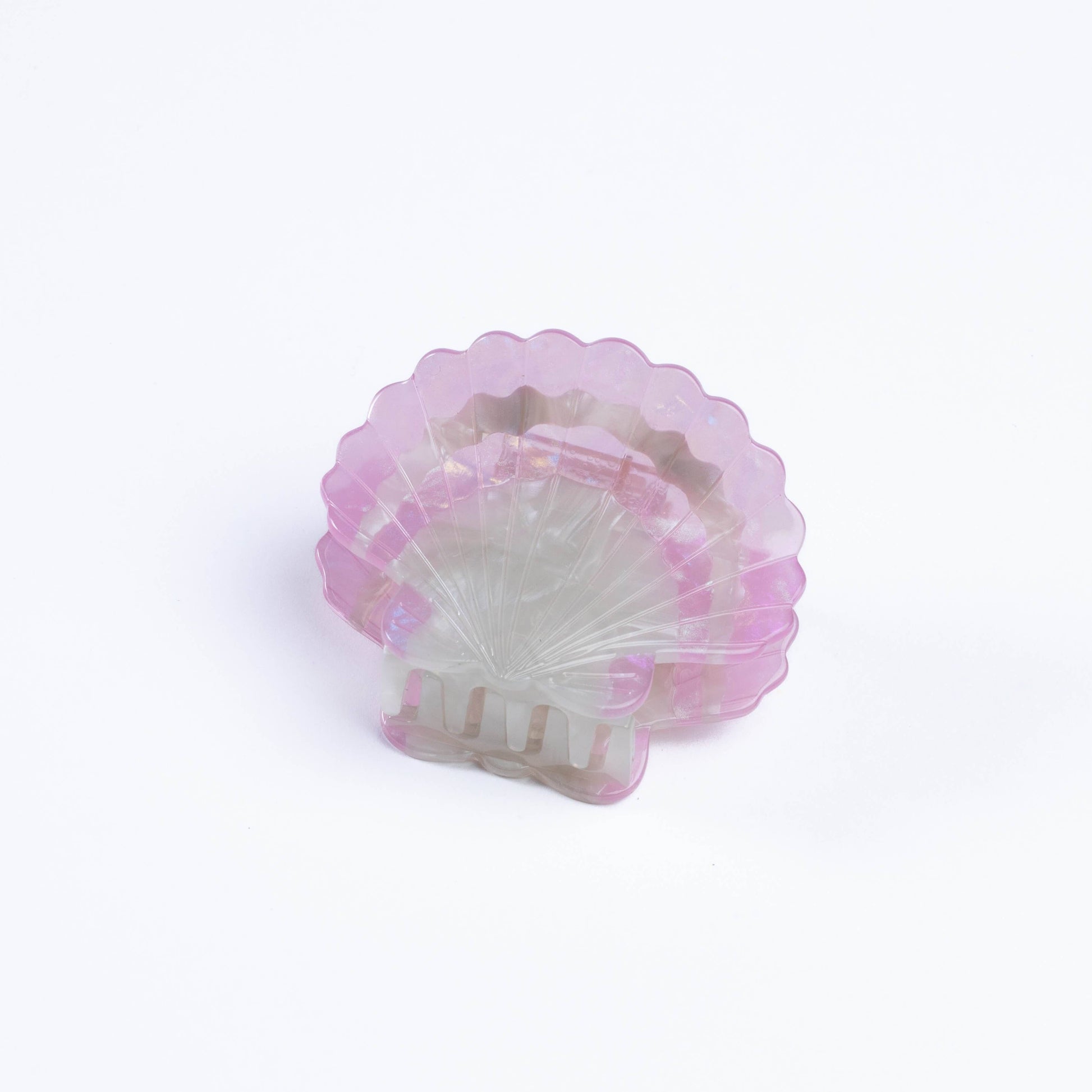 Pink and white shell-shaped hair claw on a light purple background