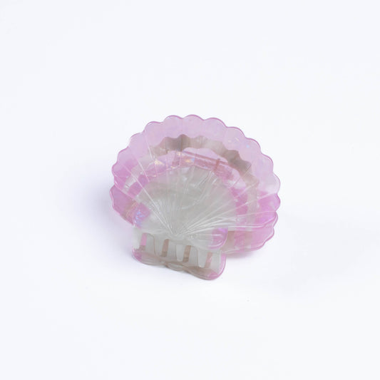 Pink and white shell-shaped hair claw on a light purple background