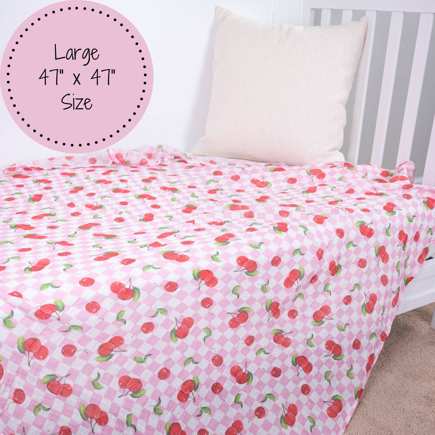 Pink bedspread with cherry pattern on a bed, labeled as 'Large 47" x 47" Size'.