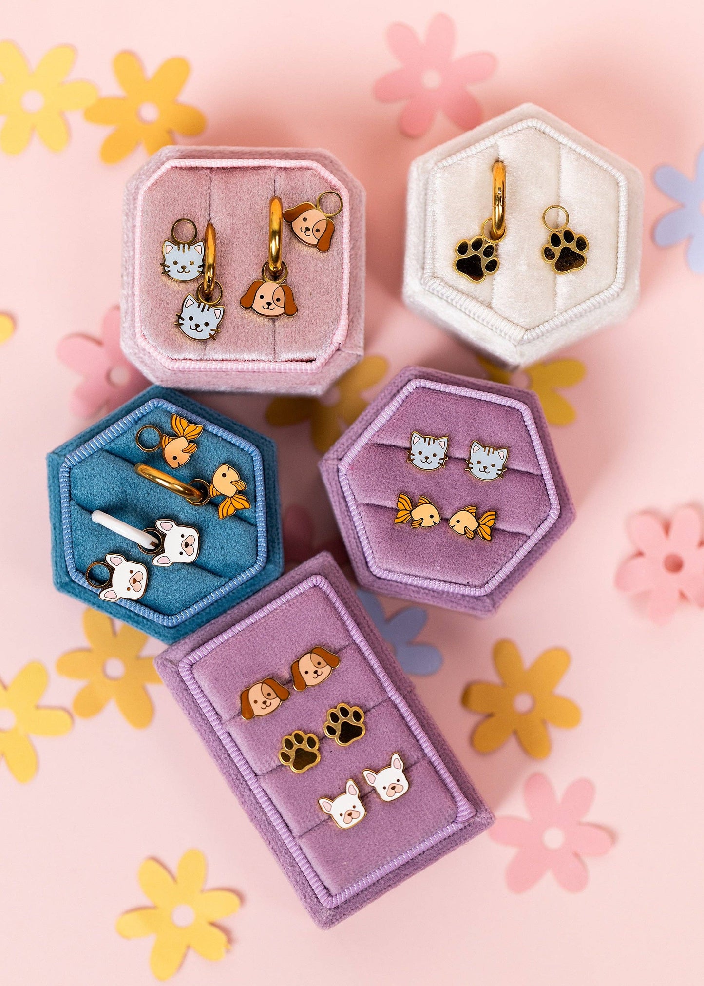 earrings in boxes on a pink background