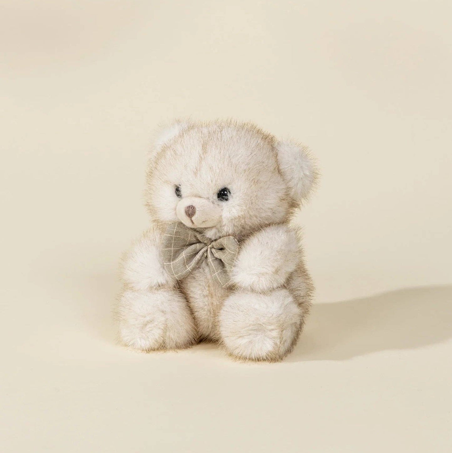 Cute teddy bear with a bow tie on a beige background