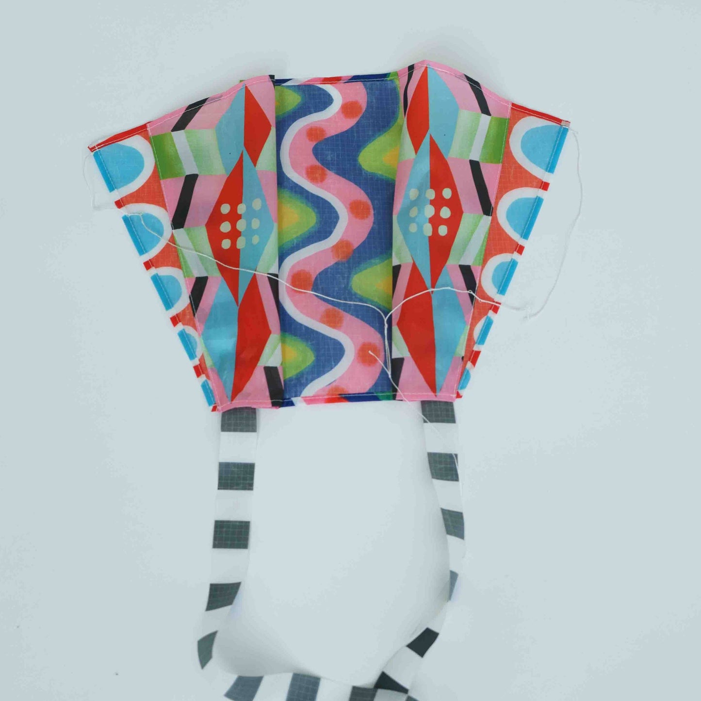 Colorful patterned kite on a light gray background