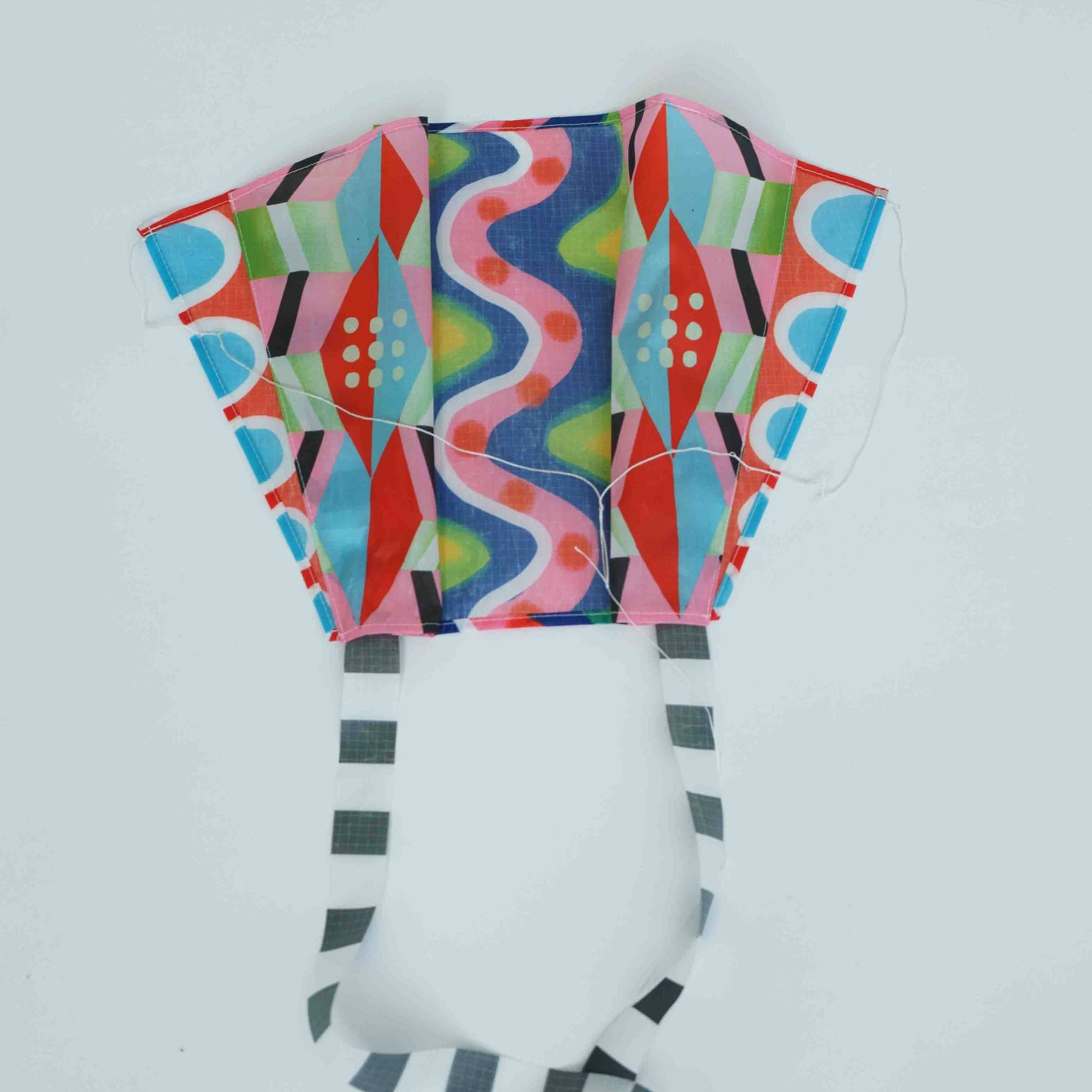 Colorful patterned kite on a light gray background