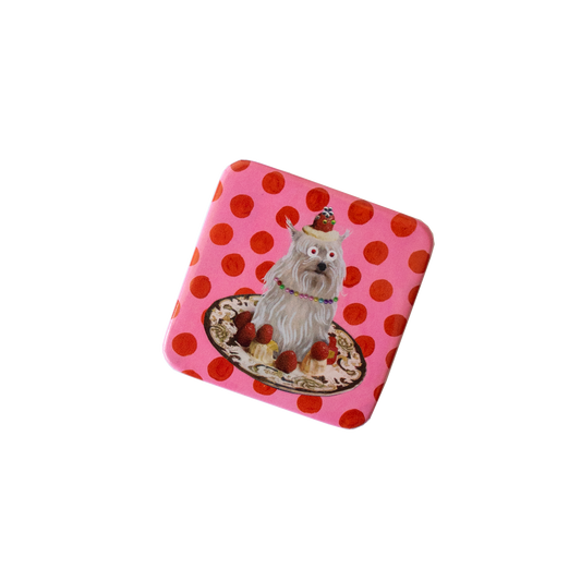 Small pinback button object with a cartoon dog design on a pink background with red polka dots