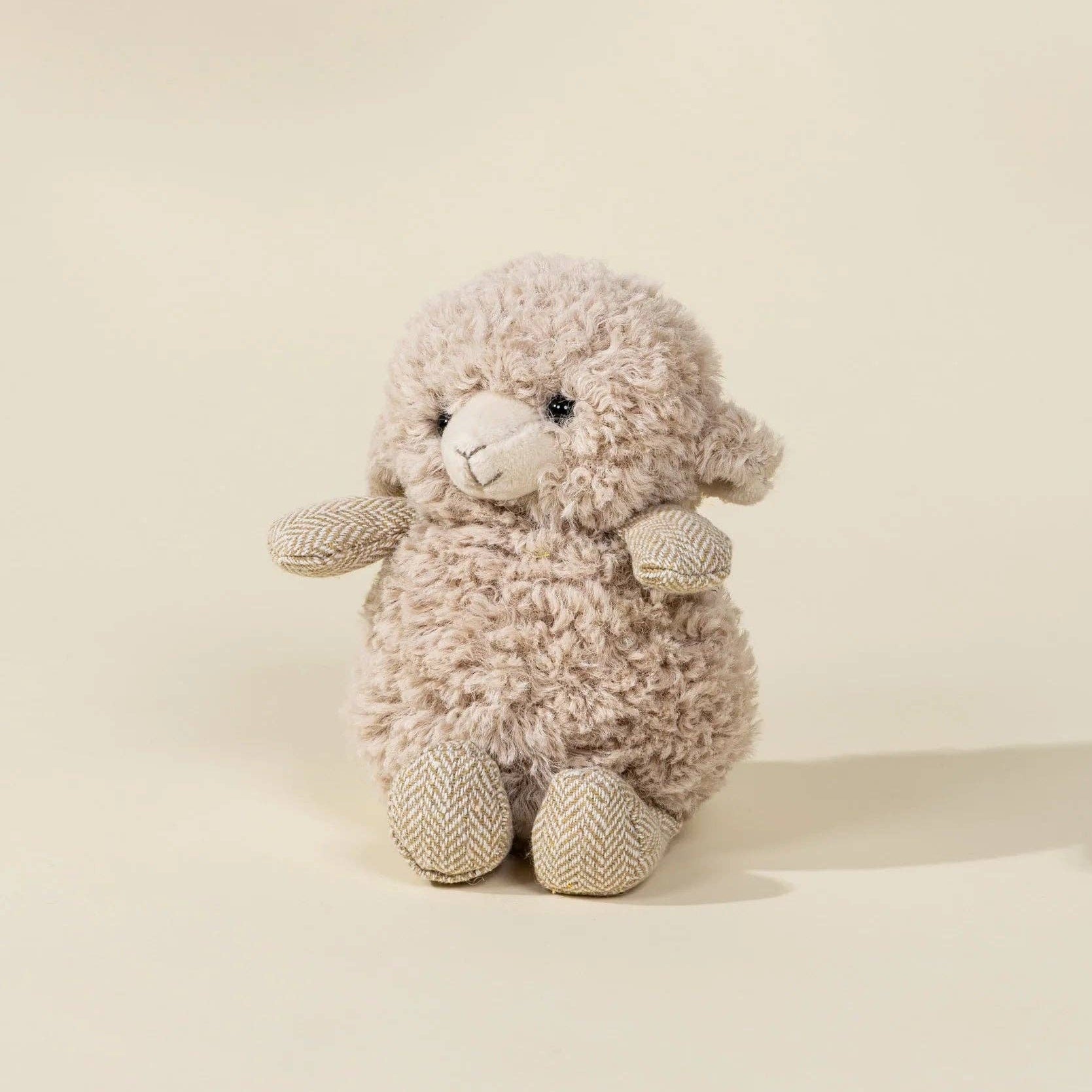 Plush toy sheep on a beige background