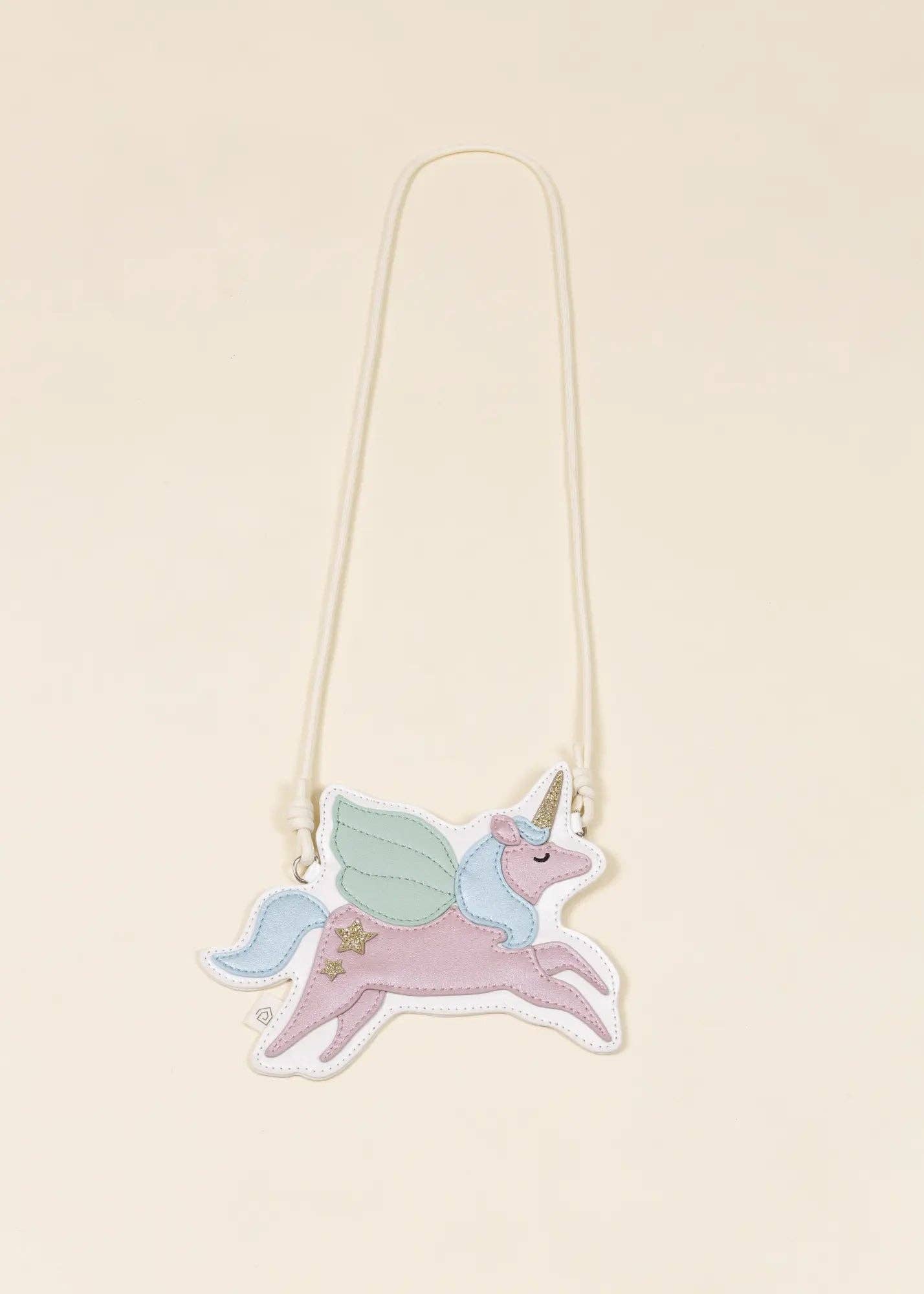 A whimsical unicorn bag with a long cream-colored strap, featuring pastel pink, mint green, and light blue colors on a warm cream background.