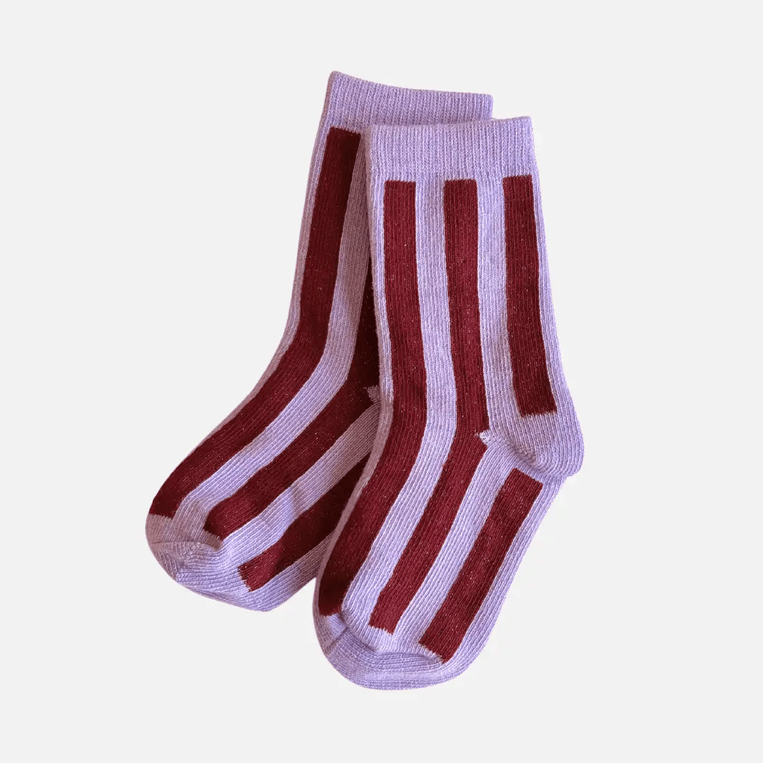 Pair of socks with red and white stripes on a light purple background