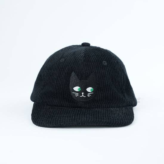 Black corduroy cap with a cat face design on a white background