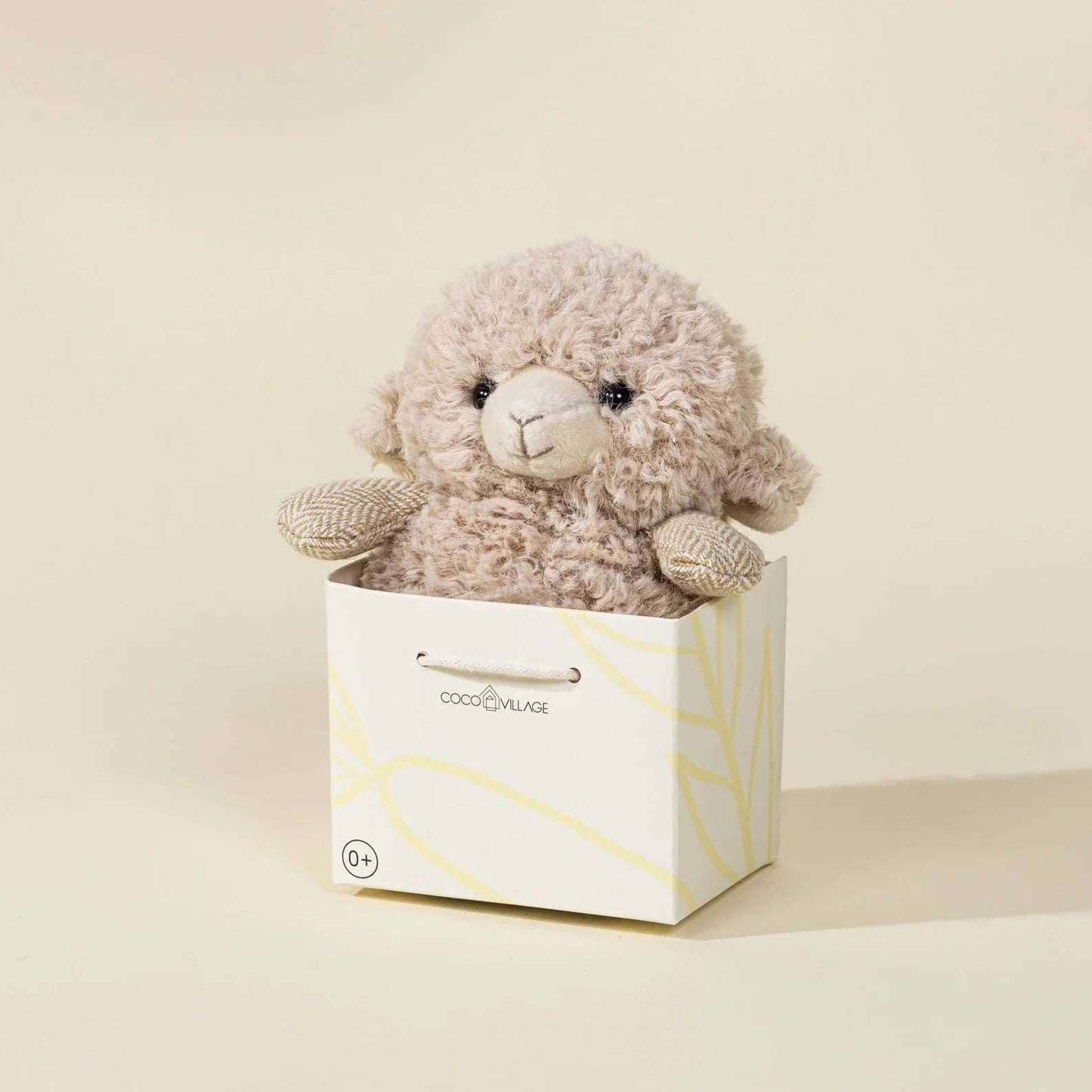 Stuffed animal toy in a white box on a beige background