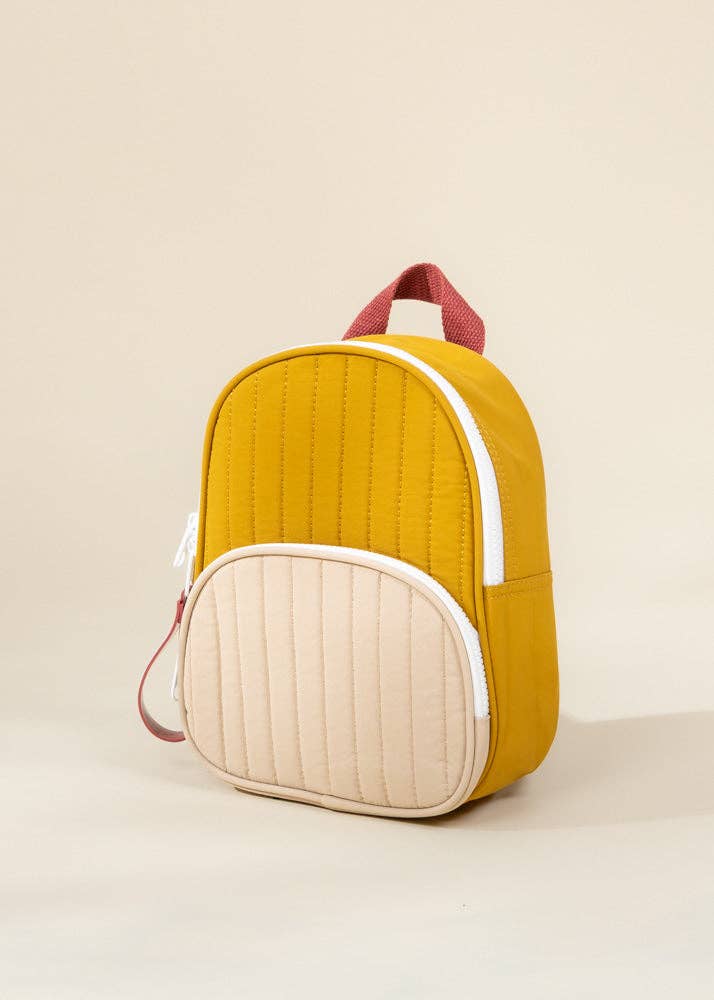 Yellow and beige quilted backpack on a beige background