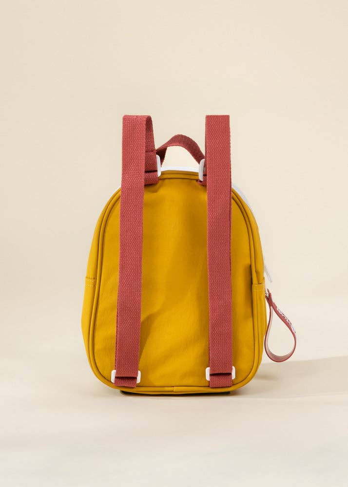 Yellow backpack with pink straps on a beige background