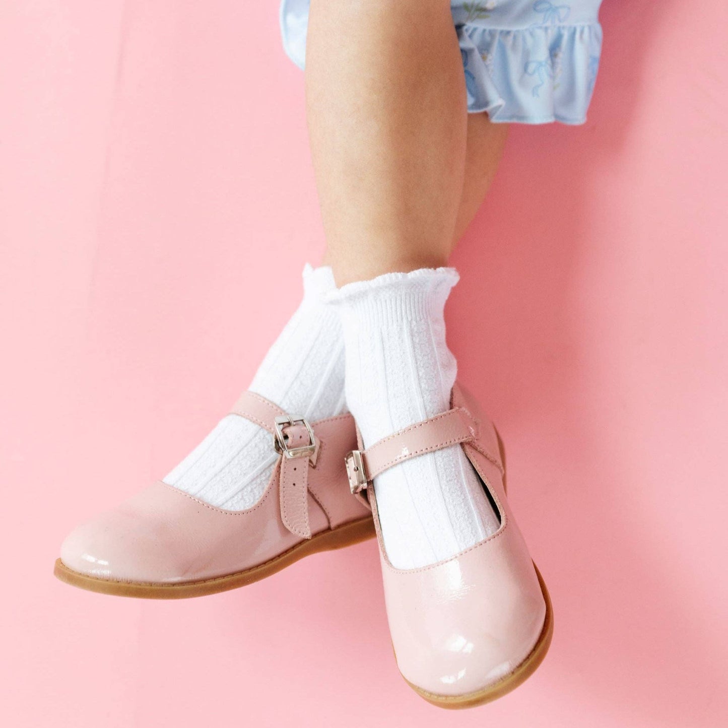Pink shoes with white socks on a pink background