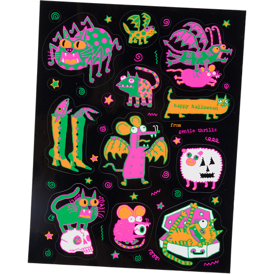 A sheet of colorful Halloween-themed stickers on a black backing, featuring whimsical monsters, stars, and text including 'Happy Halloween' and 'free genie turtle'.