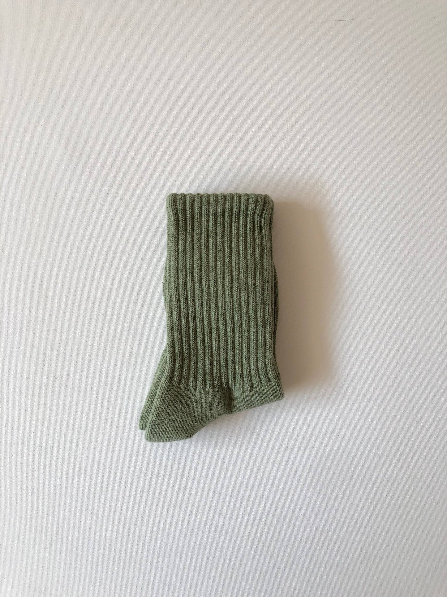 Green ribbed sock on a white background